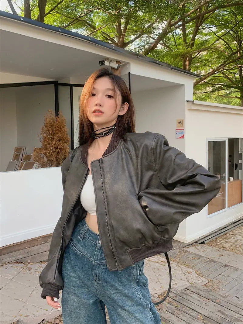 dark gray faux leather bomber jacket with ribbed cuffs and hem in retro biker style shown from the back side