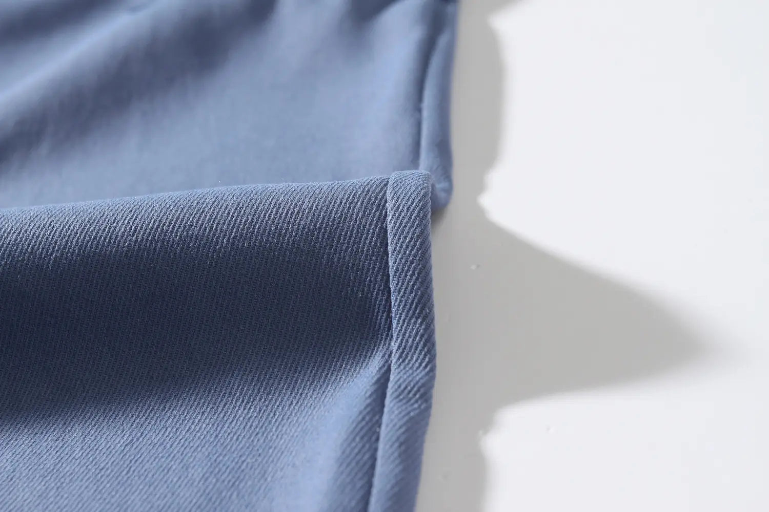 mens multi pocket cargo work pants made of soft blue denim fabric with subtle woven texture and neatly stitched seam
