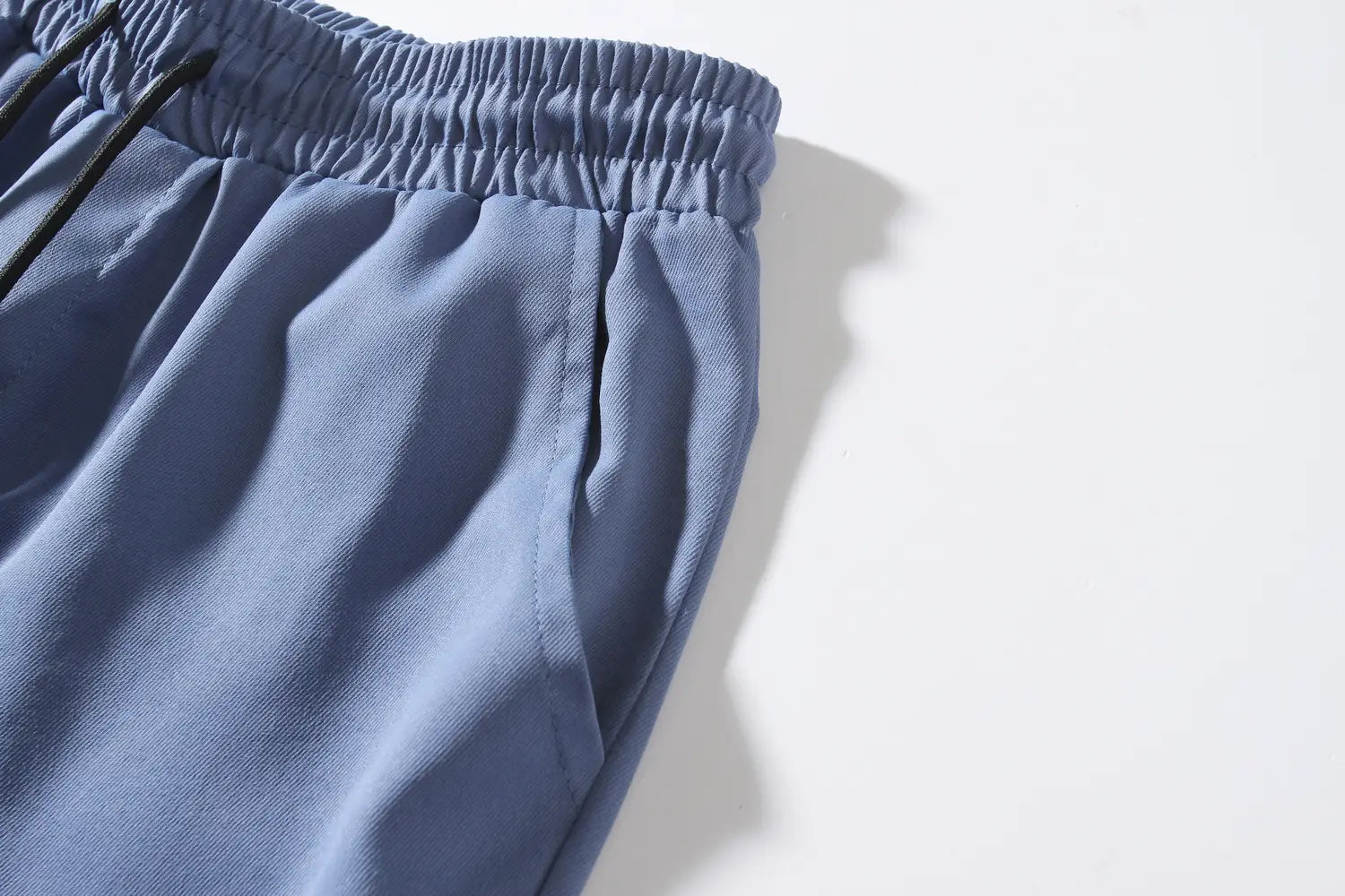 mens multi pocket cargo work pants in blue athletic fabric with an elastic waistband and black drawstrings.