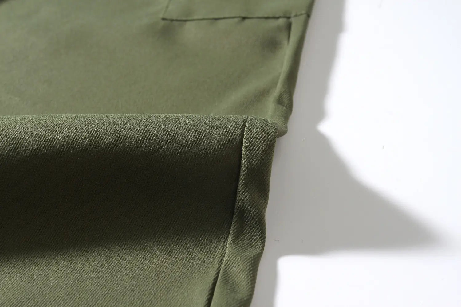 Mens multi pocket cargo work pants in olive green woven fabric with subtle texture and clean stitching.