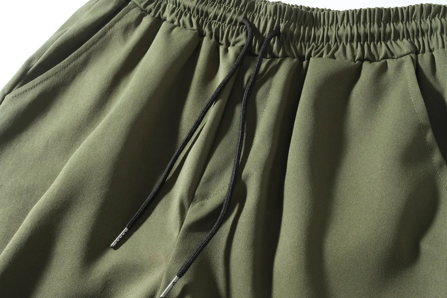 Mens multi pocket cargo work pants in olive green with a relaxed fit and a black corded drawstring waistband.