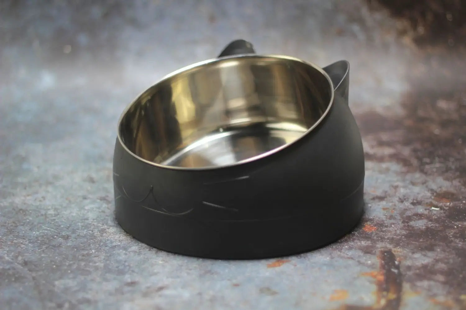 Bol pour chat surélevé en acier inoxydable avec silicone noir, doté d'une protection contre le basculement, avec un intérieur en acier inoxydable brillant et deux petites poignées latérales.