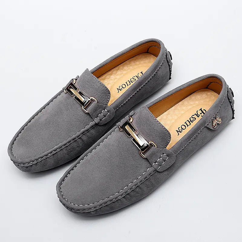 Herren-Slipper aus Samtleder mit Horsebit-Design in Grau, mit einer metallischen Schnalle und detaillierten Ziernähten, handgefertigte Gommino-Schuhen.