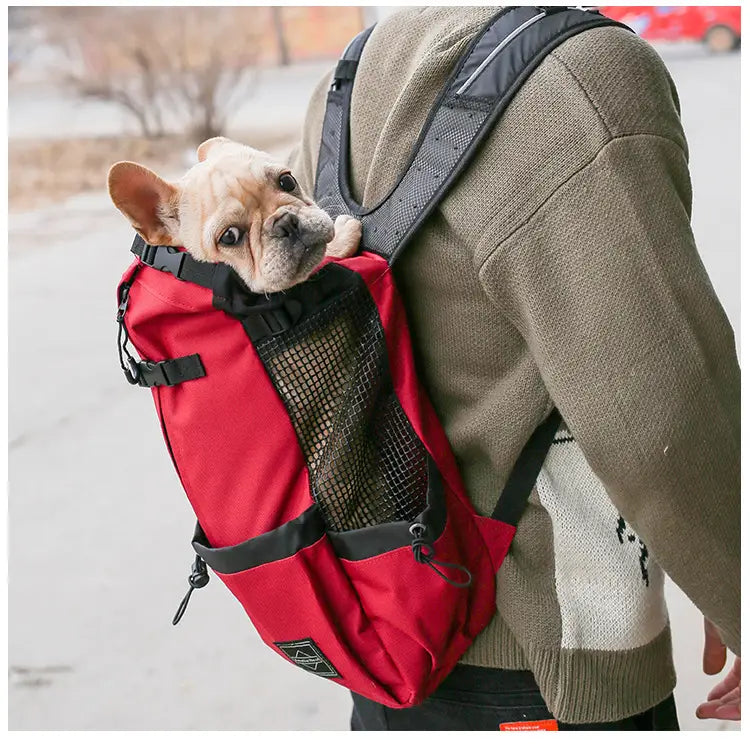 sac à dos rouge et noir de transport pour chien avec un panneau latéral en mesh, conçu comme un sac de voyage portable pour les animaux de compagnie