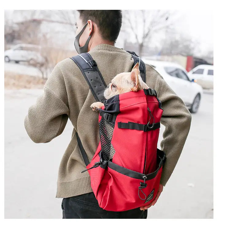 Sac à dos rouge et noir pour chien avec côtés en mesh pour la ventilation, conçu comme un sac de voyage en mesh portable.