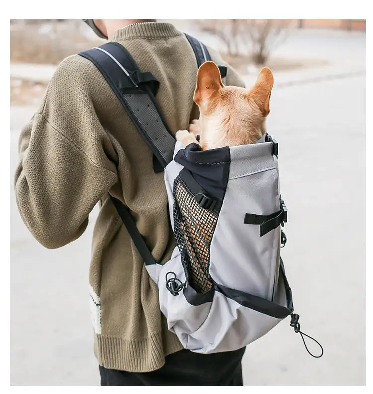 Sac à dos gris et noir de transport pour chien avec panneau latéral en mesh, conçu comme un sac de voyage en maille portable pour les animaux de compagnie.