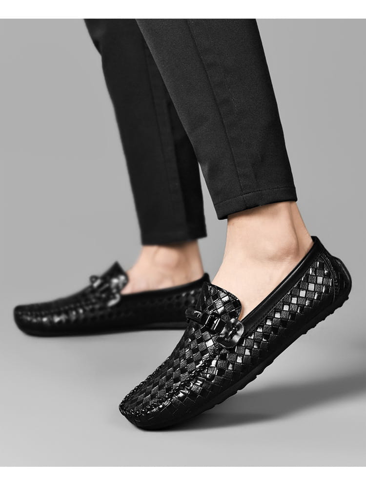 Mocassins en cuir tressé noirs avec une finition brillante et des boucles décoratives en métal, conçus comme des chaussures décontractées à enfiler.