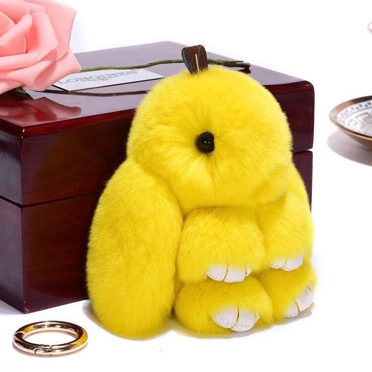 Bright yellow fluffy rabbit plush keychain with white paw tips and a black button nose soft fuzzy animal pendant 15cm.