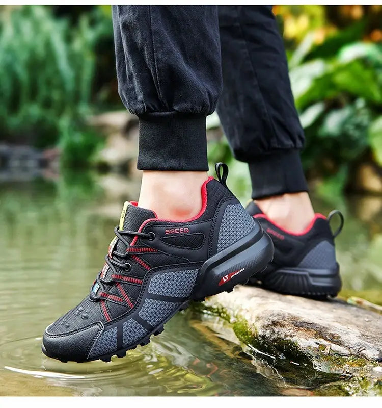 Men’s breathable mesh trail running and hiking shoe in black and red with mesh upper, rubber outsole, and speed branding on the side.
