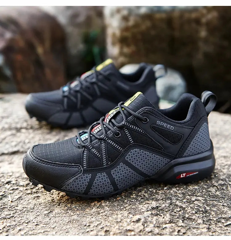 Men’s breathable mesh trail running and hiking shoes in black and gray featuring a textured mesh upper, reinforced rubber sole, and subtle geometric patterns on the side panels.