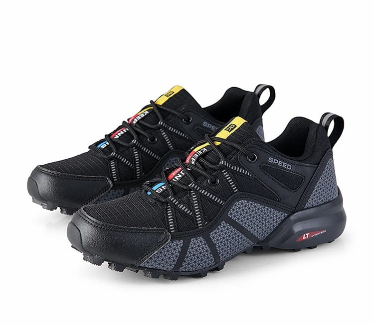 Men’s breathable mesh trail running and hiking shoes in black and gray with yellow red and blue accents on the laces and tongue.