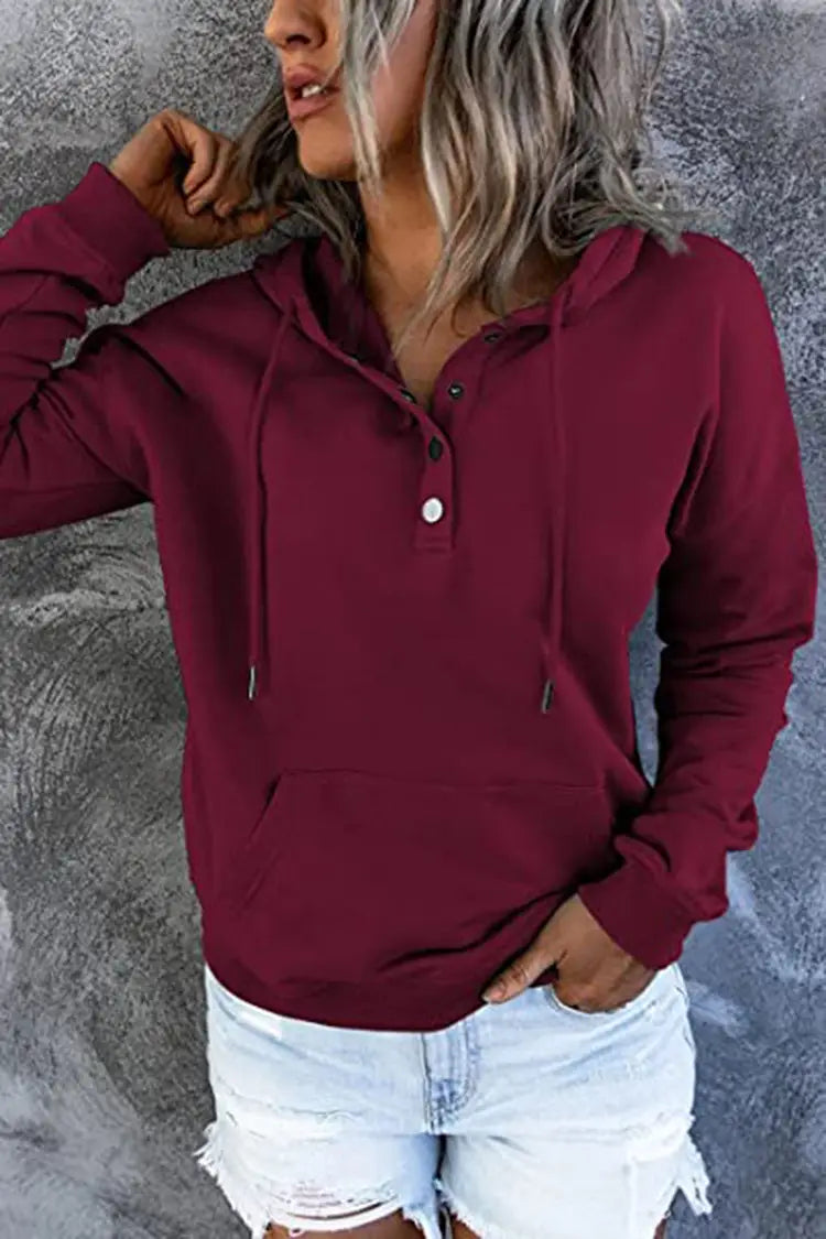 A maroon women’s button neck drawstring hooded sweatshirt with long sleeves and a henley-style front design.