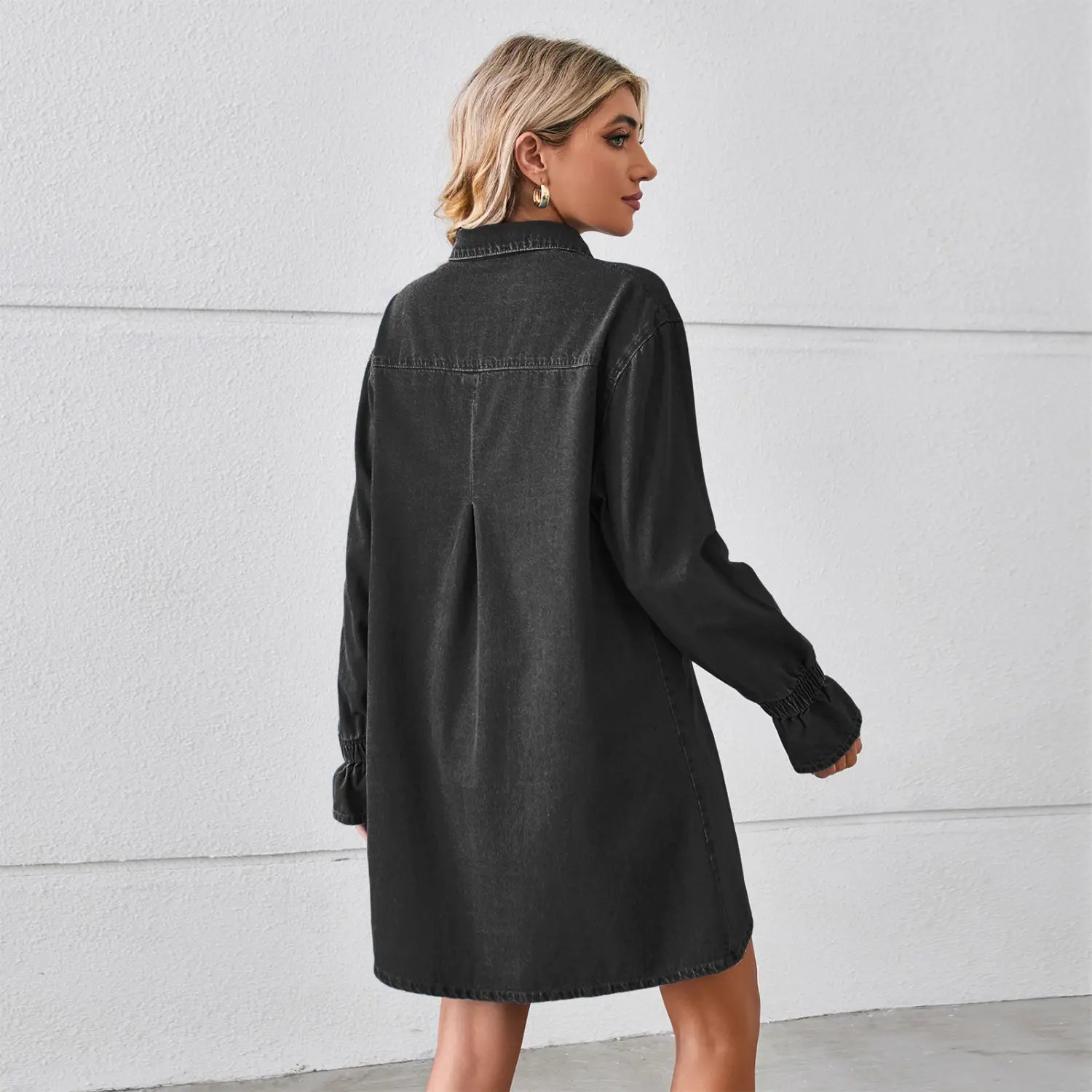 schwarzes Jeansstoff-Hemdkleid mit langen Ärmeln und gerafften Bündchen, das eine weite A-Linien-Silhouette zeigt, gefertigt aus Jeansstoff