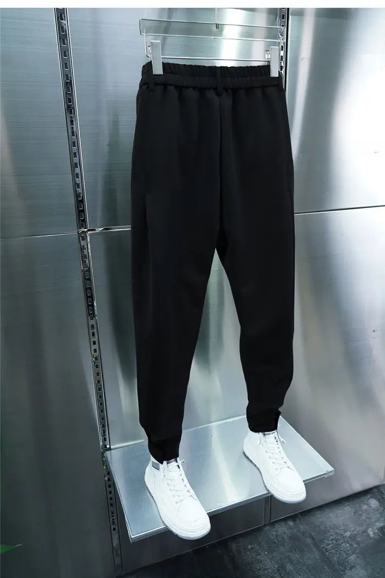 Men’s casual tapered jogger pants in black with an elastic waistband and ribbed cuffs displayed on a mannequin.