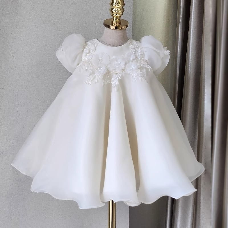 Robe de mariée princesse en dentelle florale blanche pour filles, avec ornements floraux blancs, manches bouffantes et jupe fluide.