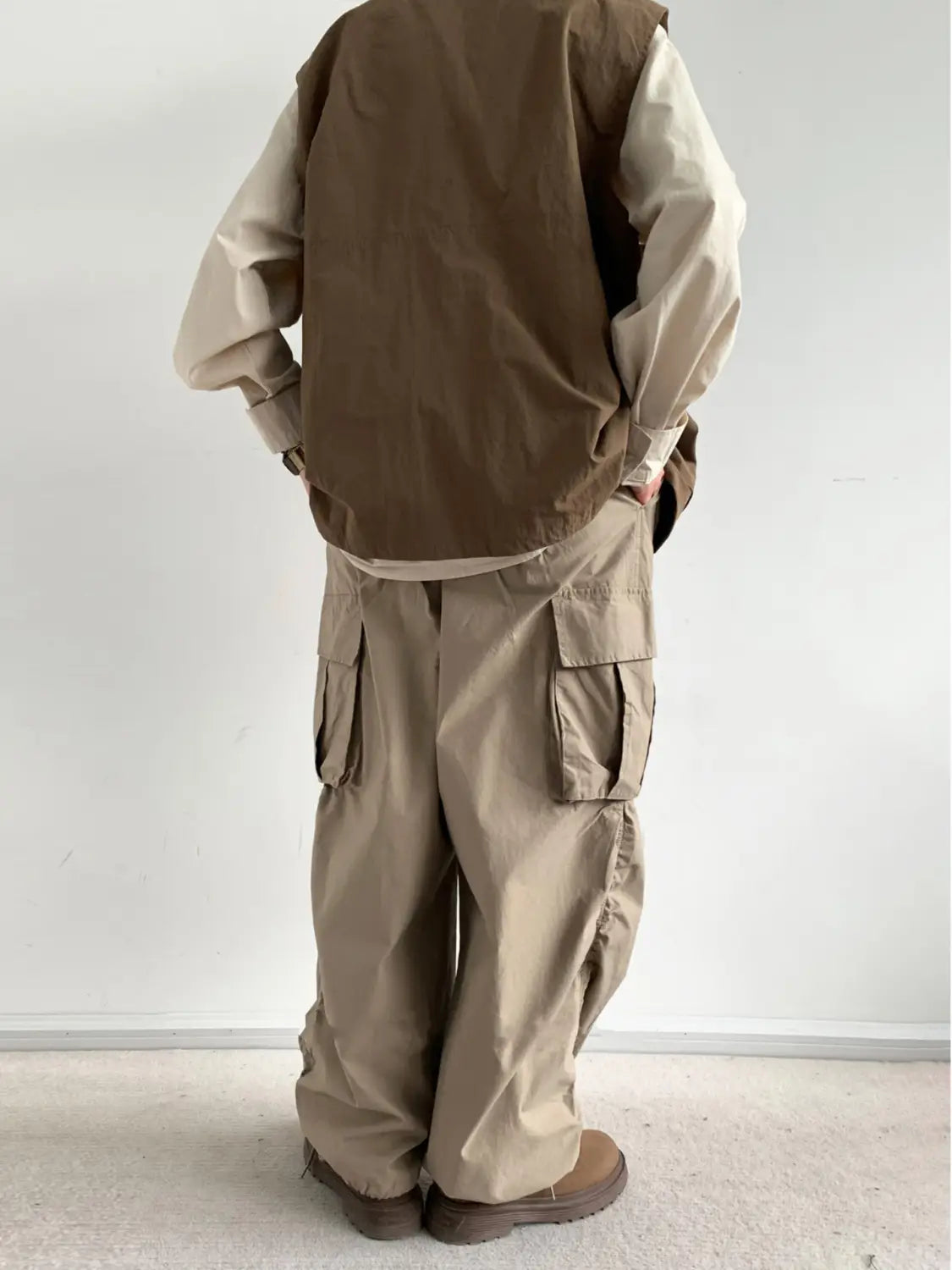 Pantalon cargo ample japonais rétro en beige, avec une coupe ample et évasée décontractée et plusieurs poches fonctionnelles, conçu pour le confort et l’utilité.