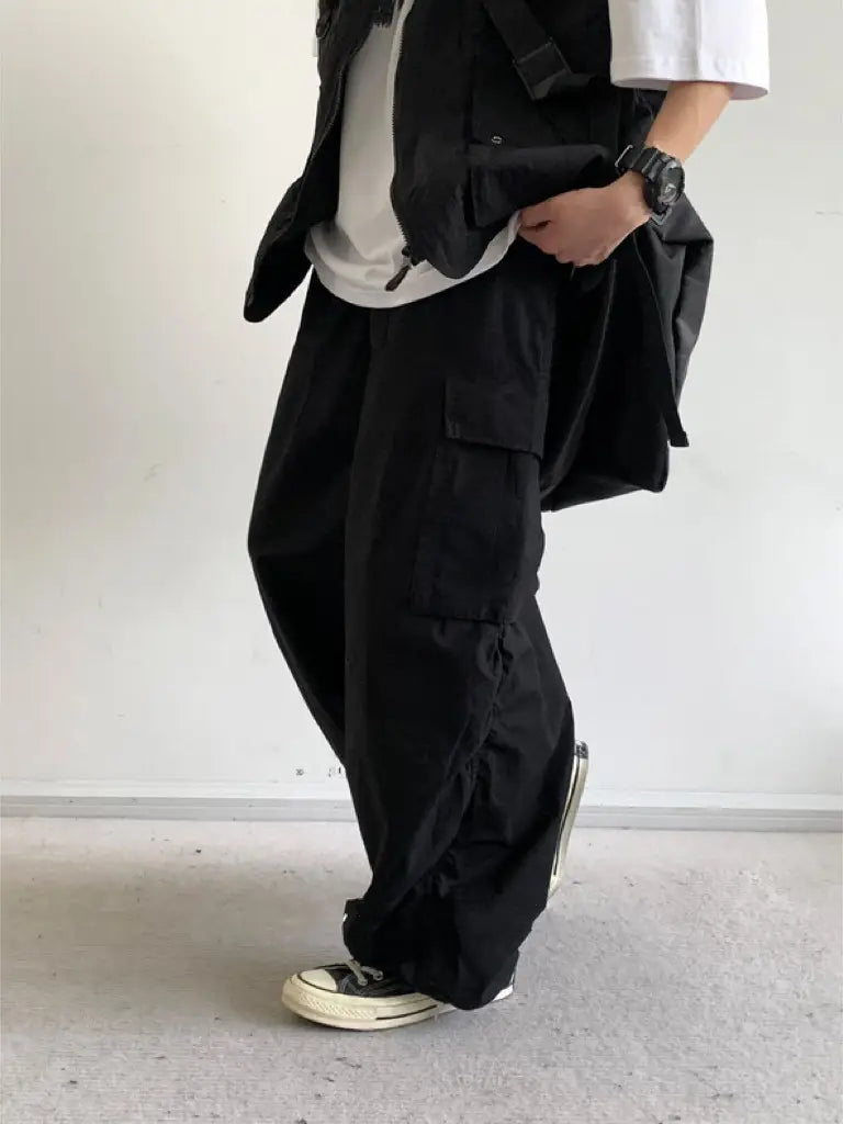 Pantalon cargo ample japonais rétro noir, doté de plusieurs poches et d’une coupe ample et évasée, réalisé dans un tissu durable.