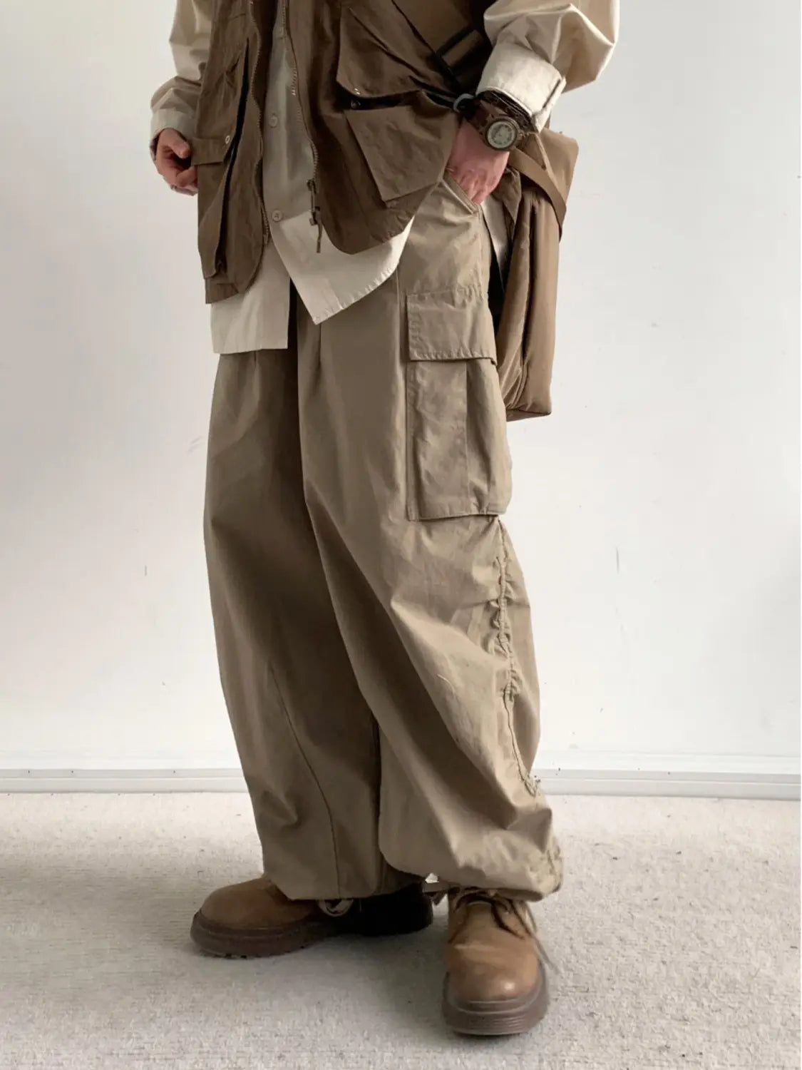 Pantalon cargo ample japonais rétro beige, doté de plusieurs poches et d’une coupe ample et évasée.