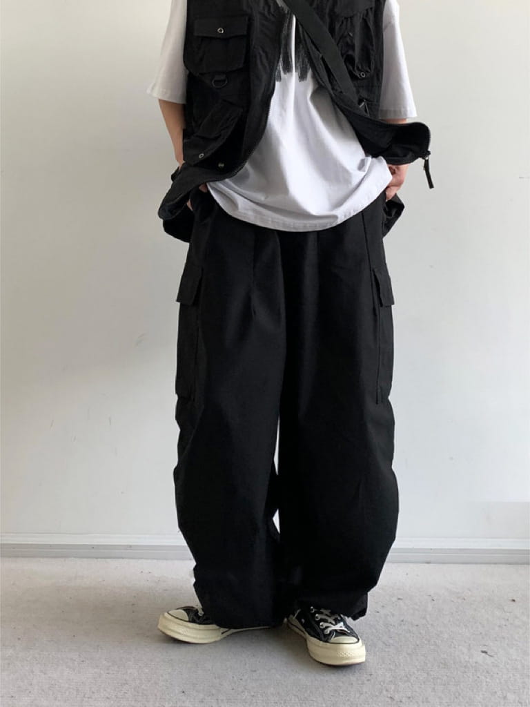 Pantalon cargo ample japonais rétro noir, doté de plusieurs poches et d’une coupe ample et évasée, offrant un ajustement décontracté.
