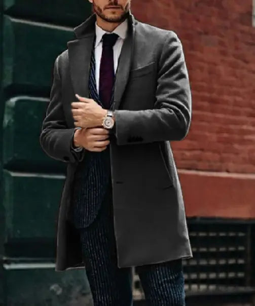 A dark gray double sided woolen mens overcoat with a notched lapel and two front pockets.