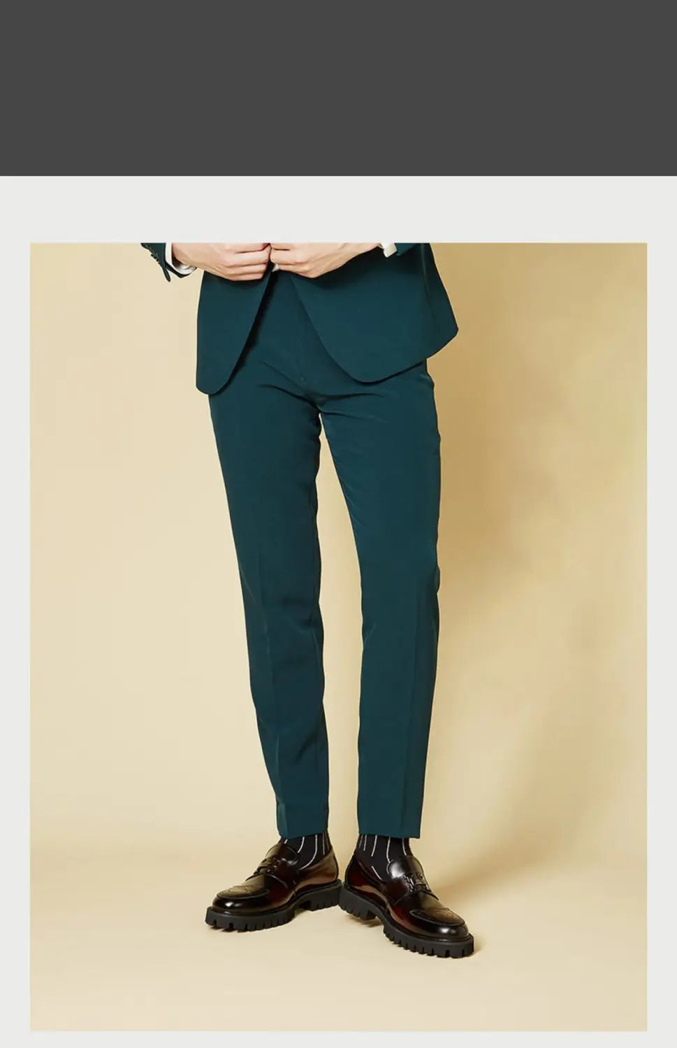 Pantalons de costume ajustés vert canard foncé, coupe moderne élégante et léger marquage, illustrés avec des mocassins en cuir bordeaux avec boucle et semelle en caoutchouc.