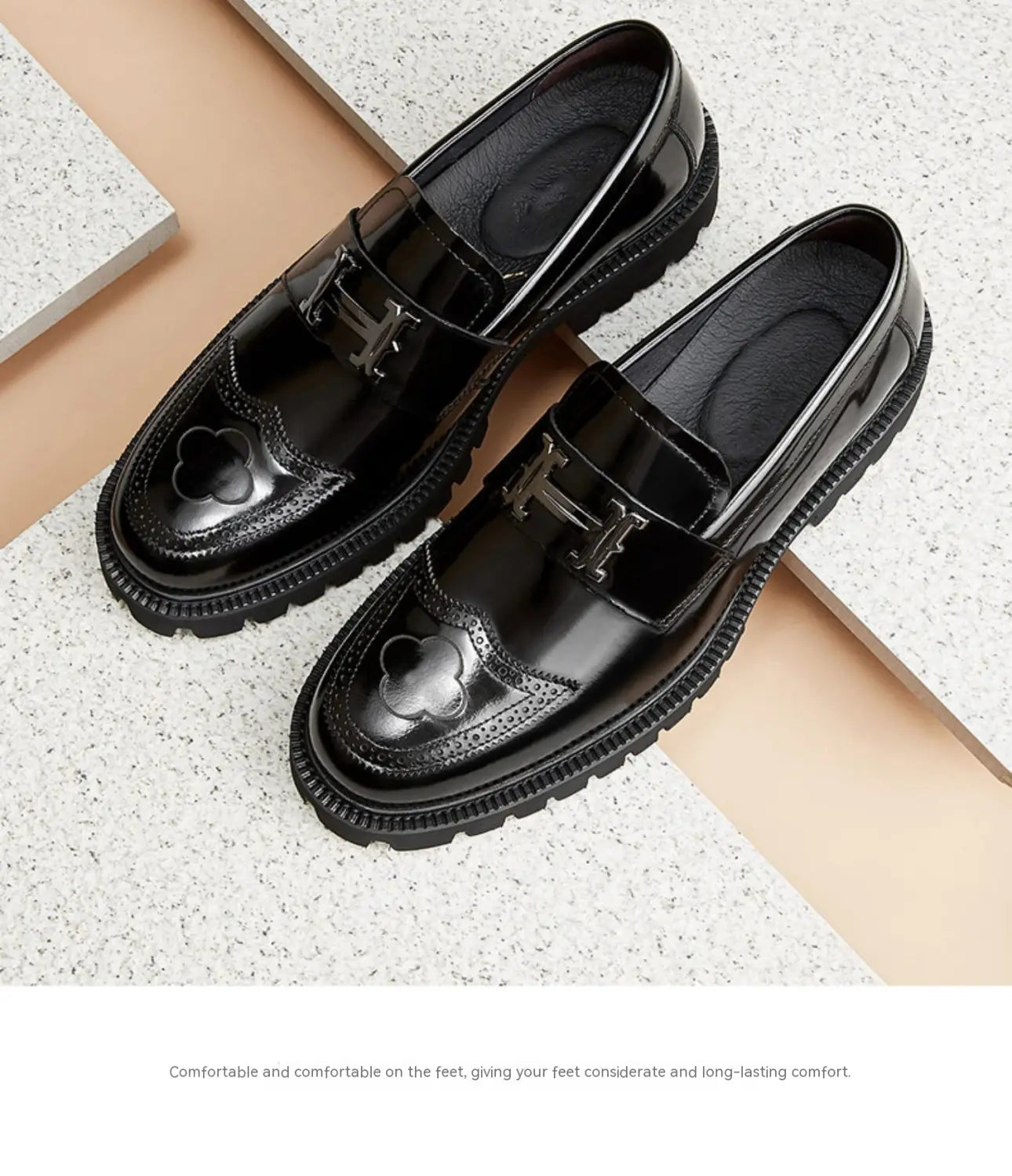 Mocassins en cuir verni noirs avec une finition lustrée, présentant un détail brogue distinctif en forme de trèfle et une boucle en forme de H à tonalité argent, conçus comme des mocassins en cuir bordeaux avec boucle et semelle en caoutchouc.