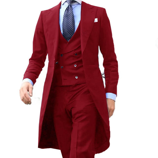 A rich burgundy slim fit men three piece suit with a double breasted design, matching vest and trousers, black buttons, and a light blue dress shirt perfect for wedding groom formal attire.