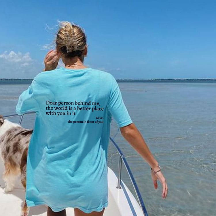 women’s oversized light blue short-sleeved cotton t-shirt showing the back side with a printed slogan design