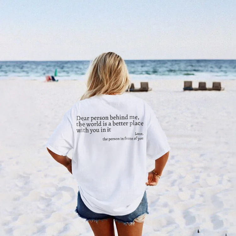 White oversized cotton t-shirt for women with black printed slogan on the back reading dear person behind me the world is a better place with you in it.