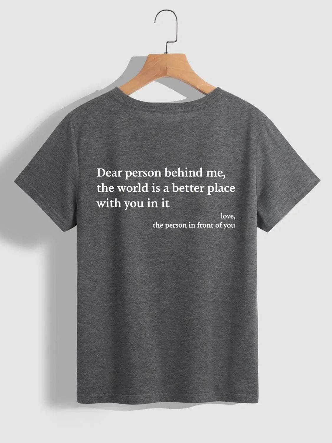 the back side of a dark gray heathered cotton women’s oversized slogan print graphic t-shirt with white printed text