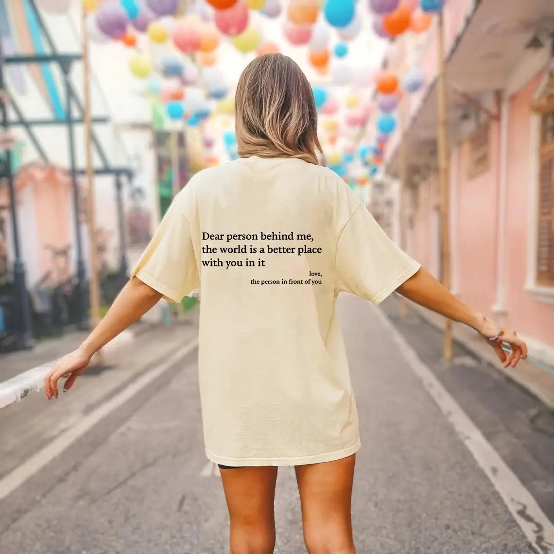 Cream-colored oversized cotton t-shirt for women with black printed slogan text on the back.