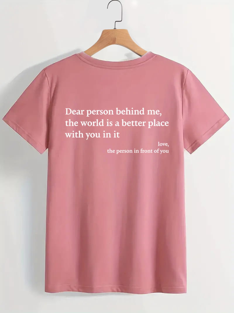The back side of a soft pink women’s oversized short-sleeved t-shirt with a white slogan print graphic.