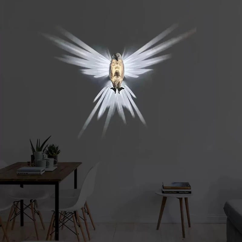 Golden owl-shaped wall lamp made from 3d printed geometric material featuring radiant white wing light projections.