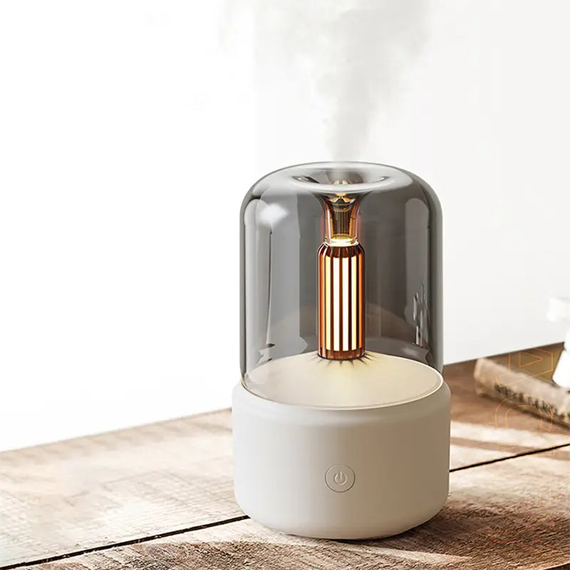 A sleek candle light aroma diffuser usb humidifier with a 120ml capacity featuring a translucent gray dome over a gold-toned vertical diffuser and a matte white base.