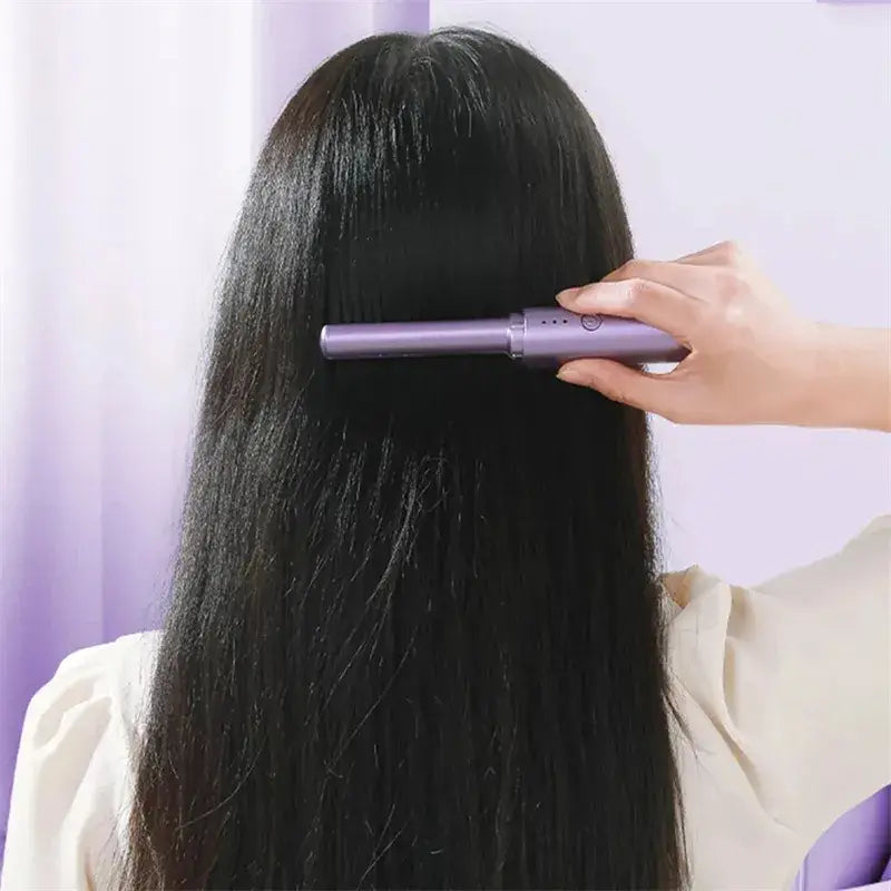 Purple wireless hair straightener brush with ceramic comb being used on long black hair for portable styling