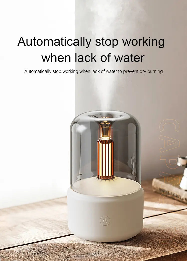 A sleek modern candlelight aroma diffuser usb mist humidifier with a white base and transparent glass dome housing a gold toned central column and a 120ml capacity.