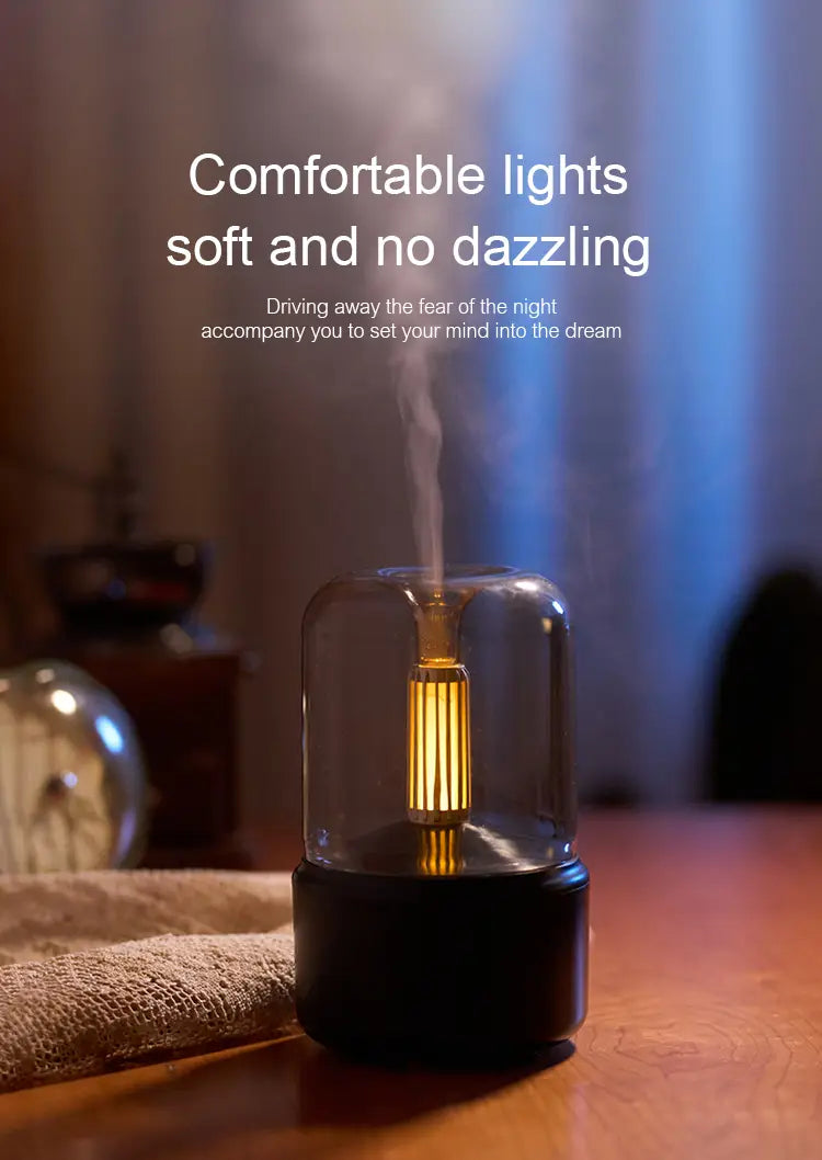 A sleek black and clear glass candlelight aroma diffuser USB mist humidifier with a glowing golden filament inside emitting soft mist to create a calming ambiance.