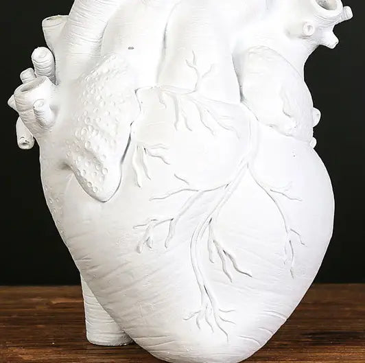 White anatomically detailed heart-shaped vase made of resin with a textured surface and embossed vascular structures designed as a Nordic sculpture flower pot.