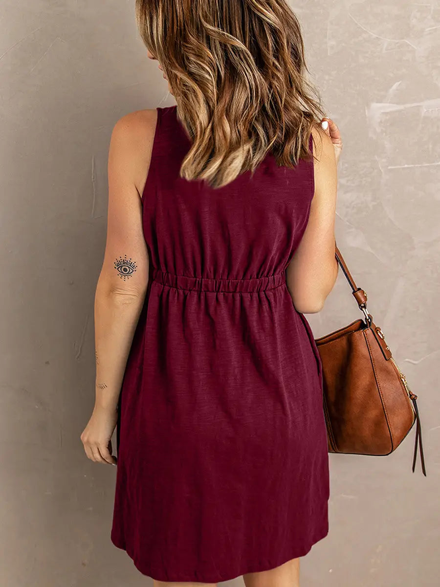 Sleeveless v neck button front a line dress in maroon with a gathered waist and soft flowing fabric.