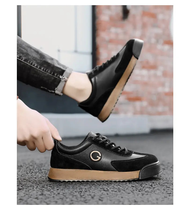 Baskets décontractées imperméables en cuir pour homme en daim noir et cuir, avec une semelle en caoutchouc tan et un logo circulaire sur le côté.