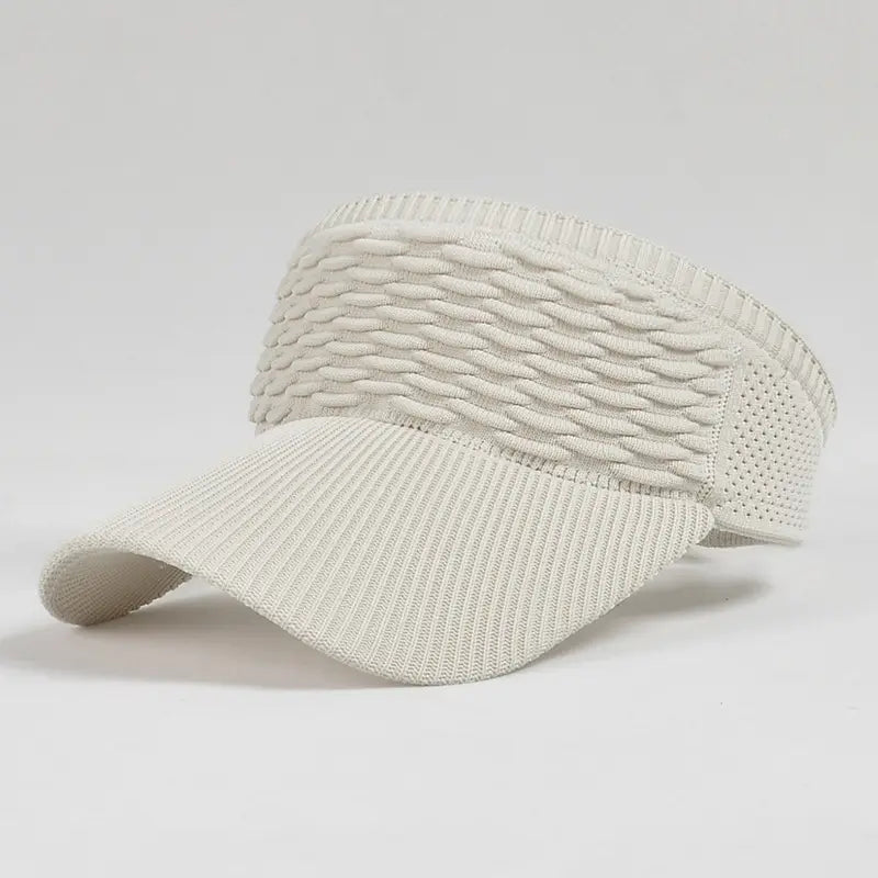 Cream-colored knitted visor cap with woven texture and breathable mesh panels designed for summer sports use.