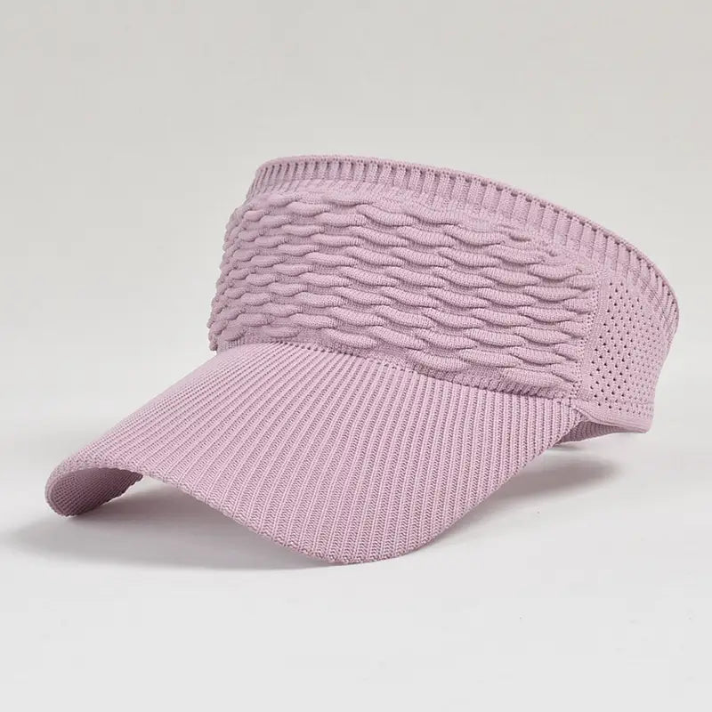 A soft lavender knitted visor cap featuring a textured wavy pattern band and breathable mesh sections designed for summer sports use.
