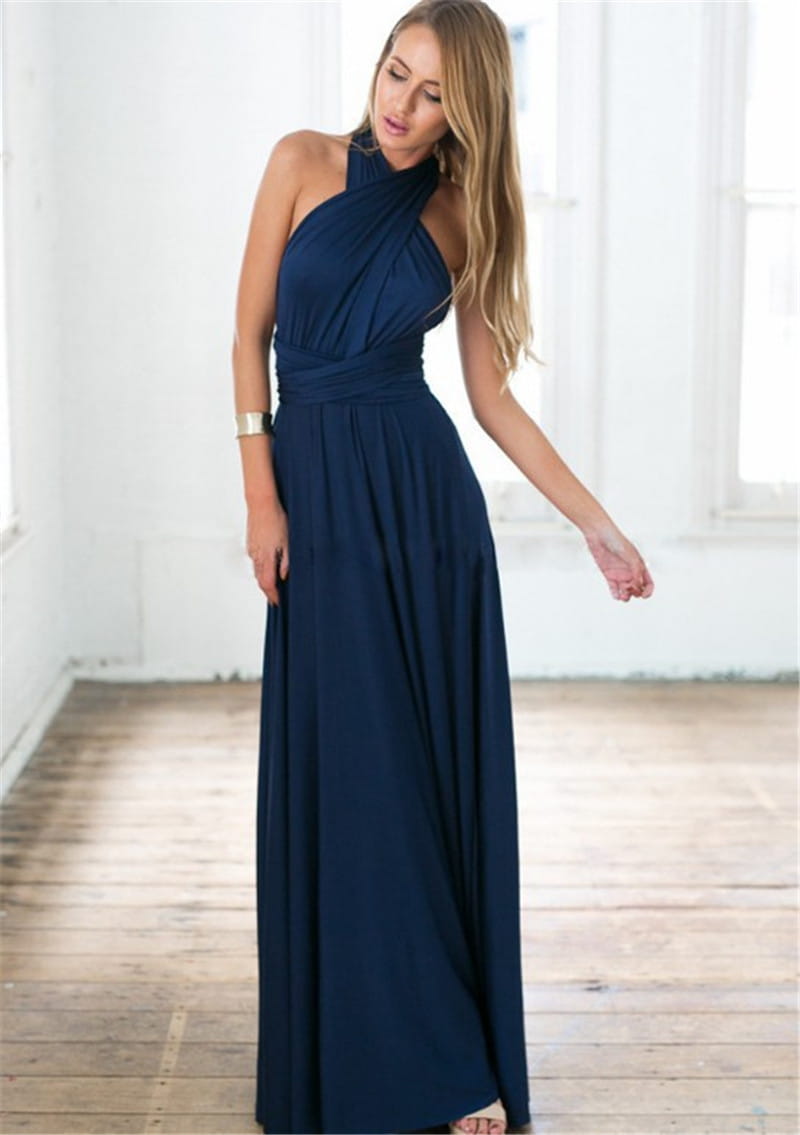 A flowing navy blue boho multiway halter neck maxi dress with a draped bodice and pleated skirt.