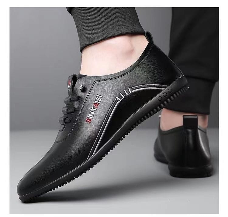 Zapatilla plana casual de cuero negro con logotipado en rojo y blanco en el lateral, material ligero y transpirable y diseño con cordones.
