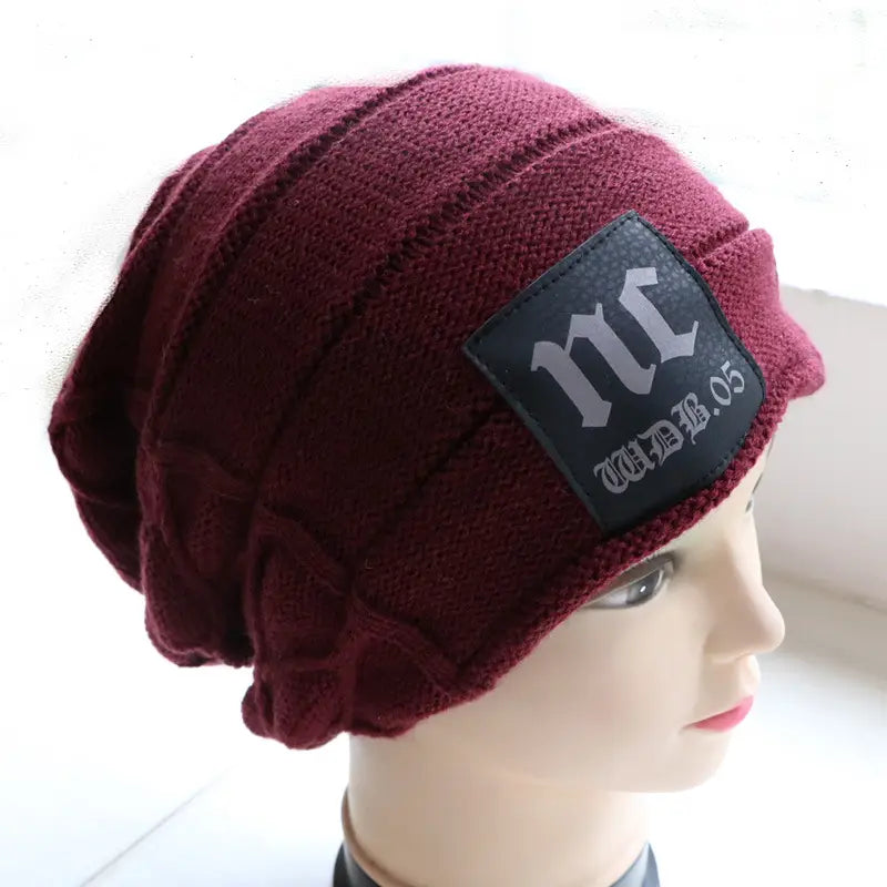 men’s fleece lined knitted winter beanie hat in maroon with a black patch featuring white gothic-style lettering.