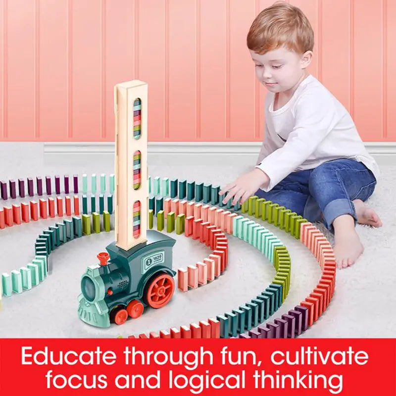 A green and red plastic domino train toy with a tall colorful tower on its back from the automatic electric building blocks set.