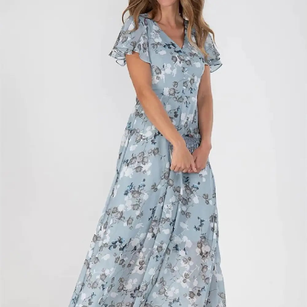 Une robe longue d’été florale bleu clair, fluide, avec des manches courtes volantées et un décolleté en V.