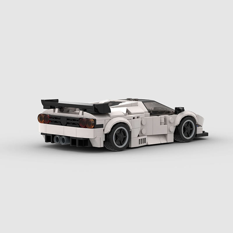 Rear view of white and black Lego Technic sports car model Diablo GT featuring detailed rear spoiler taillights and exhaust pipes made from building blocks.
