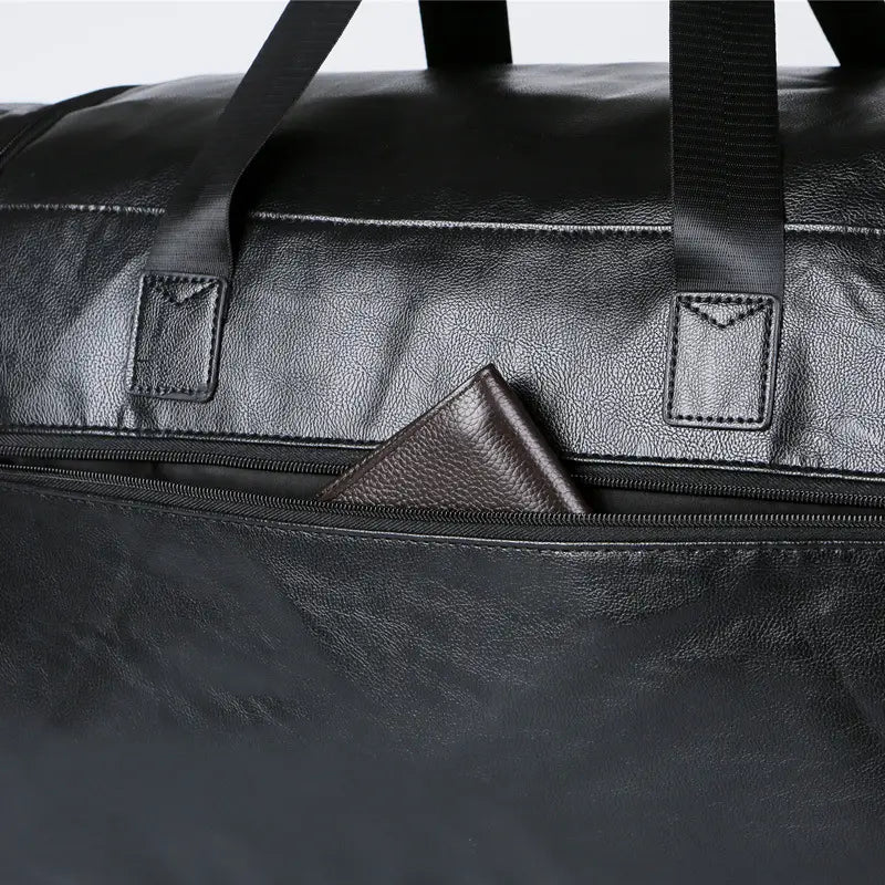 Black leather men’s pu leather travel duffel bag with sturdy handles and a zipper pocket holding a matching wallet with 20-35 liter capacity.