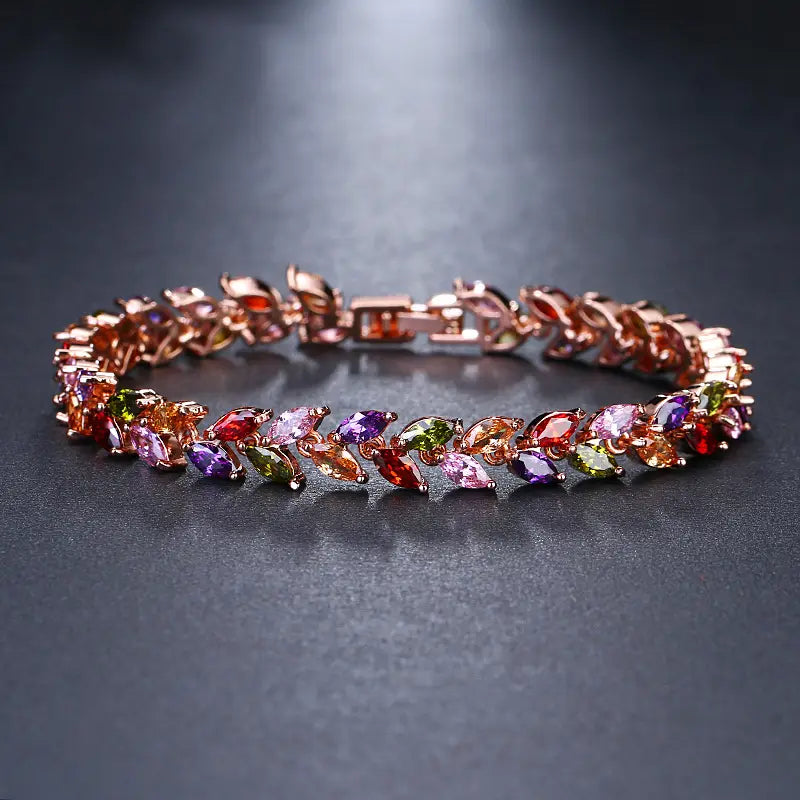 A rose gold marquise zircon leaf tennis bracelet in polished silver featuring a vibrant array of multicolored marquise-cut gemstones.